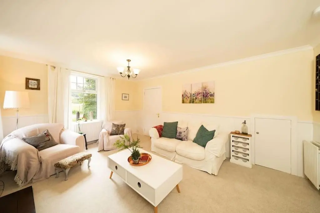 a living room with two couches and a table at Red Squirrel Cottage, Family & Pet Friendly Adventure Retreat, Strathdon, Aberdeenshire in Towie