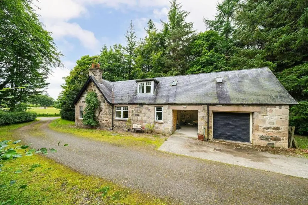 an old stone house with a garage on a road at Red Squirrel Cottage, Family & Pet Friendly Adventure Retreat, Strathdon, Aberdeenshire in Towie
