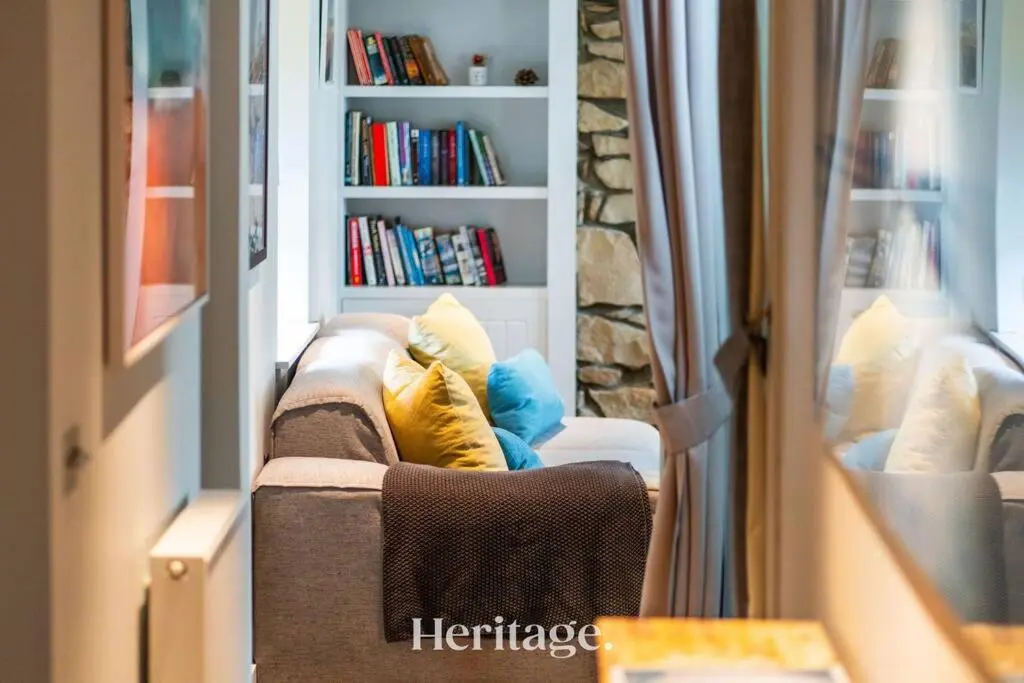 a living room with a couch and a book shelf at Beach Cottage, Pet & Family Friendly Stay in Moray in Lossiemouth