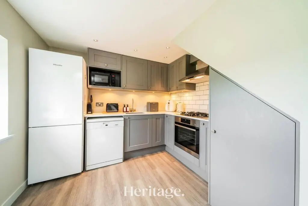 a kitchen with gray cabinets and white appliances at Beach Cottage, Pet & Family Friendly Stay in Moray in Lossiemouth