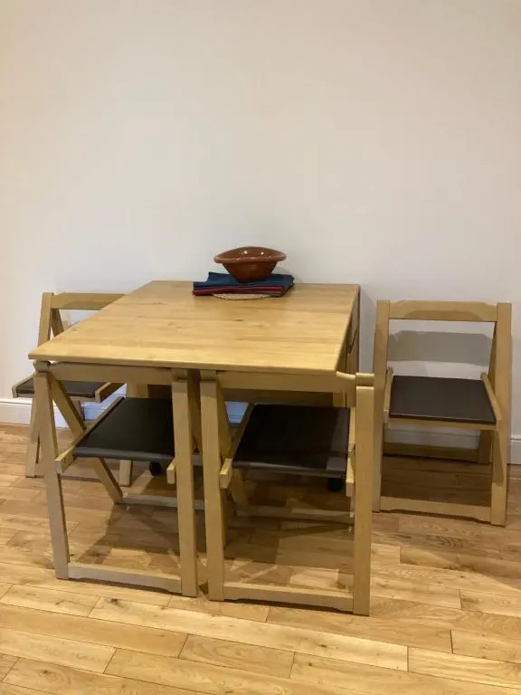 a wooden table with two chairs and a bowl on top at Flat 2 at Inverness City in Inverness