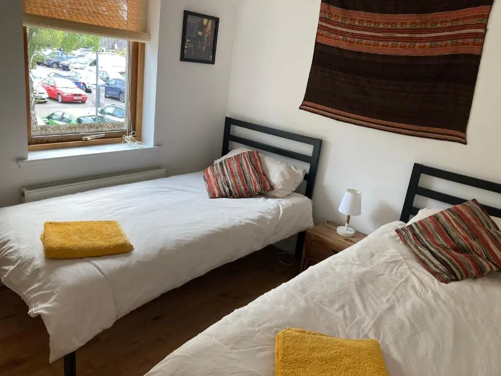 a bedroom with two beds and a window at Flat 2 at Inverness City in Inverness