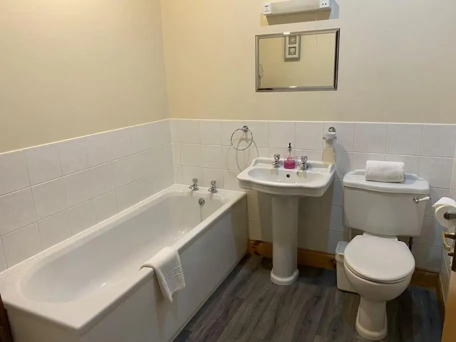 a bathroom with a tub and a toilet and a sink at Dalfaber House Luxury holidays in the Highlands in Aviemore