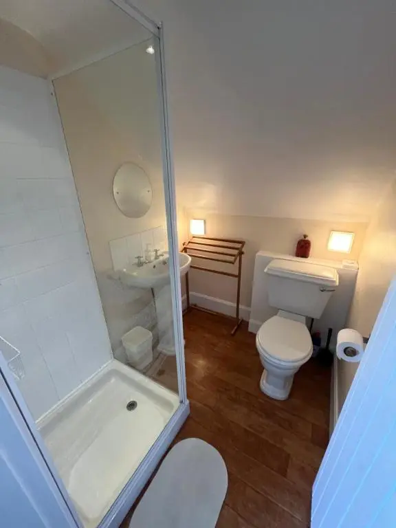 a bathroom with a shower and a toilet and a sink at Old Lock-keeper's Cottage in Fort Augustus