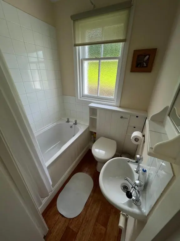 a bathroom with a tub and a toilet and a sink at Old Lock-keeper's Cottage in Fort Augustus