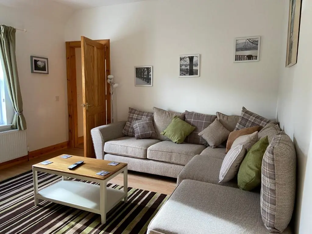 a living room with a couch and a table at Dalvey Ploughmans Cottage in Forres