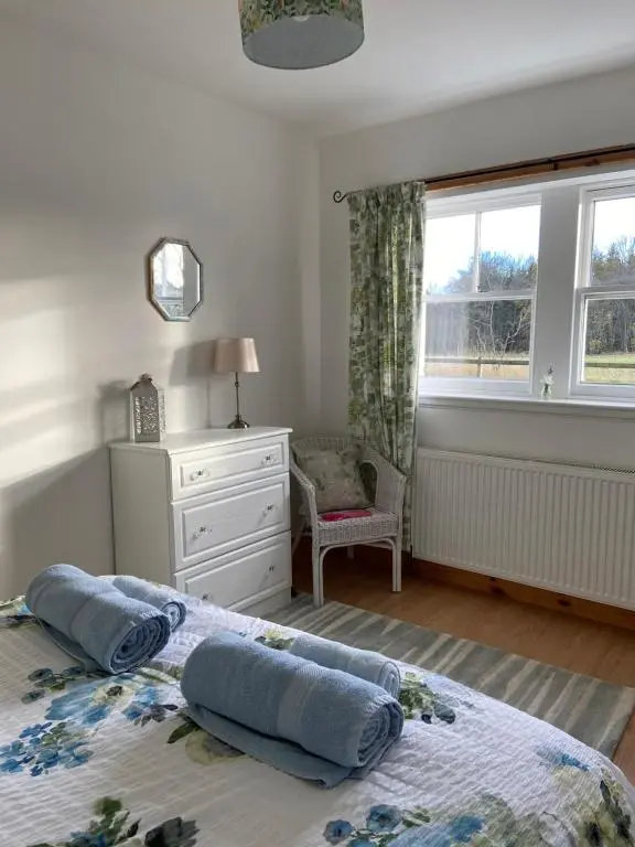 a bedroom with two pillows on a bed with a window at Dalvey Ploughmans Cottage in Forres