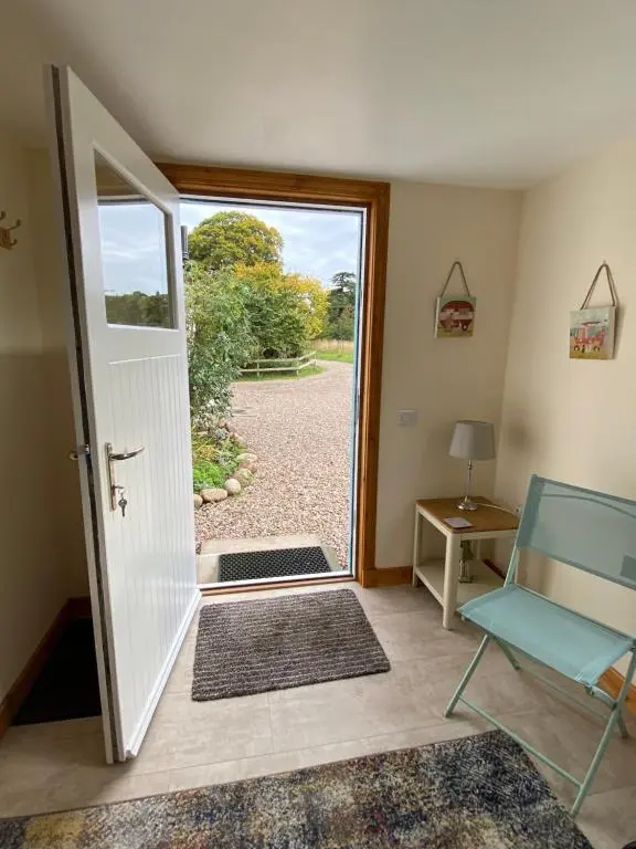 an open door with a view of a yard at Dalvey Ploughmans Cottage in Forres