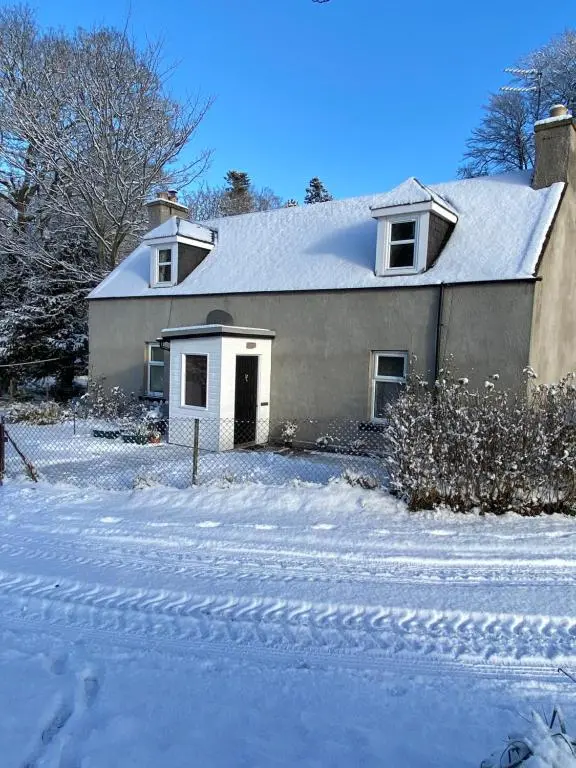 a house with a snow covered driveway in front of it at Dalvey Mill Cottage in Forres