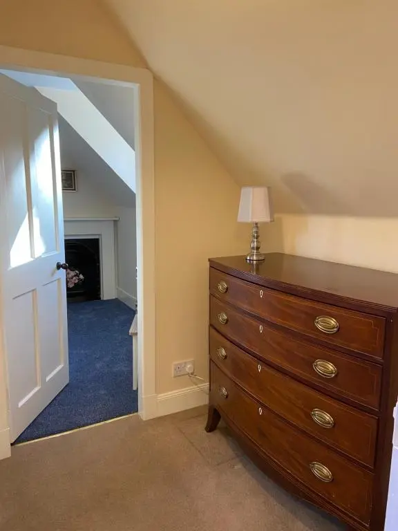 a bedroom with a dresser with a lamp on it at Dalvey Mill Cottage in Forres