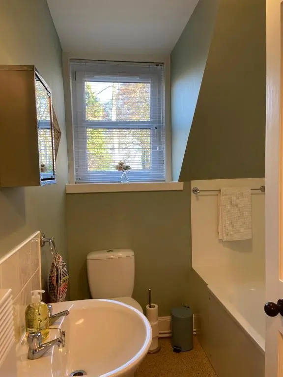 a bathroom with a sink and a toilet and a window at Dalvey Mill Cottage in Forres
