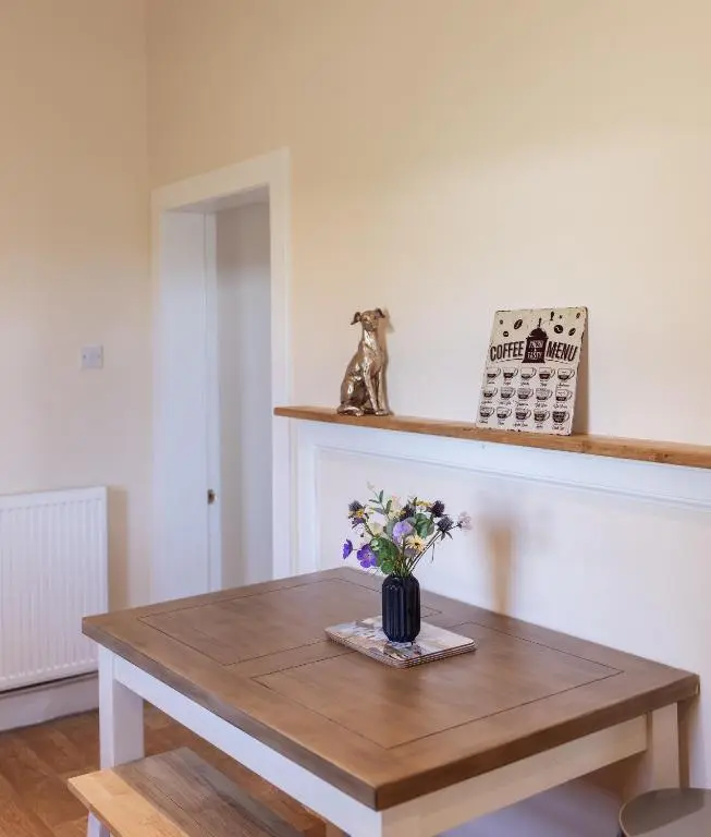 a wooden table with a vase of flowers on it at Dalvey Abbotshill Farm House in Forres