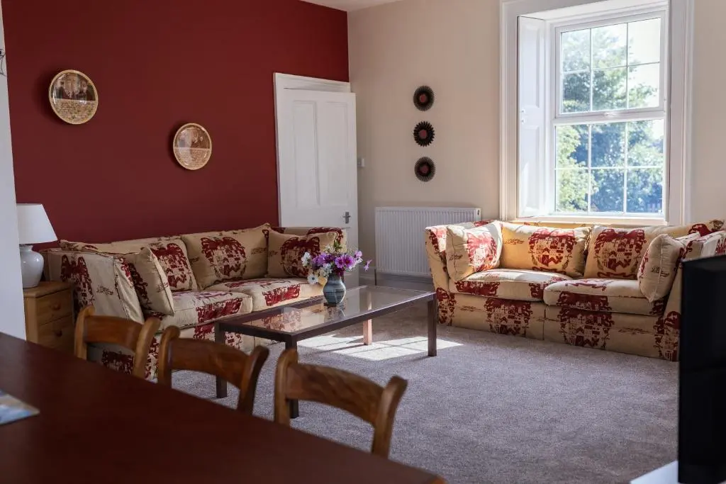 a living room with a couch and a table at Dalvey Abbotshill Farm House in Forres