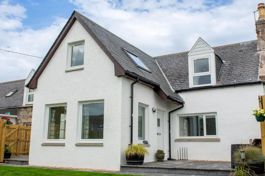 a white house with a black roof at Stunning Country Cottage in Ardross Close To Traitors Castle & NC500 in Boath