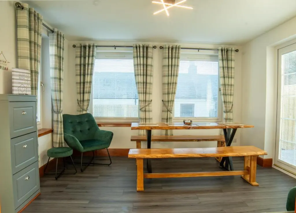 a room with a table and a chair and windows at Stunning Country Cottage in Ardross Close To Traitors Castle & NC500 in Boath