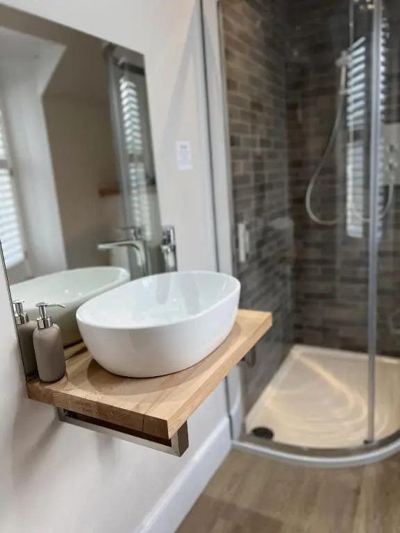 a bathroom with a white sink and a shower at No. Ten Guesthouse in Tain