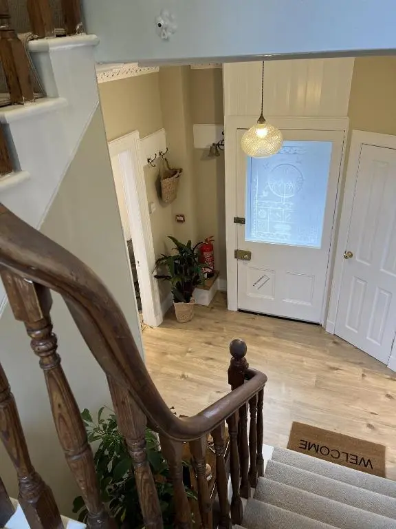 a stairway with a wooden stair case and a door at No. Ten Guesthouse in Tain