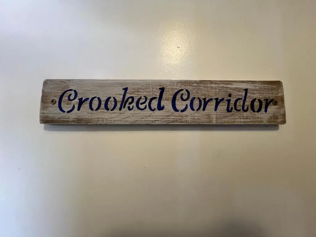 a sign that reads crooked controller hanging on a wall at The Garden Arms Pub and Rooms in Gardenstown
