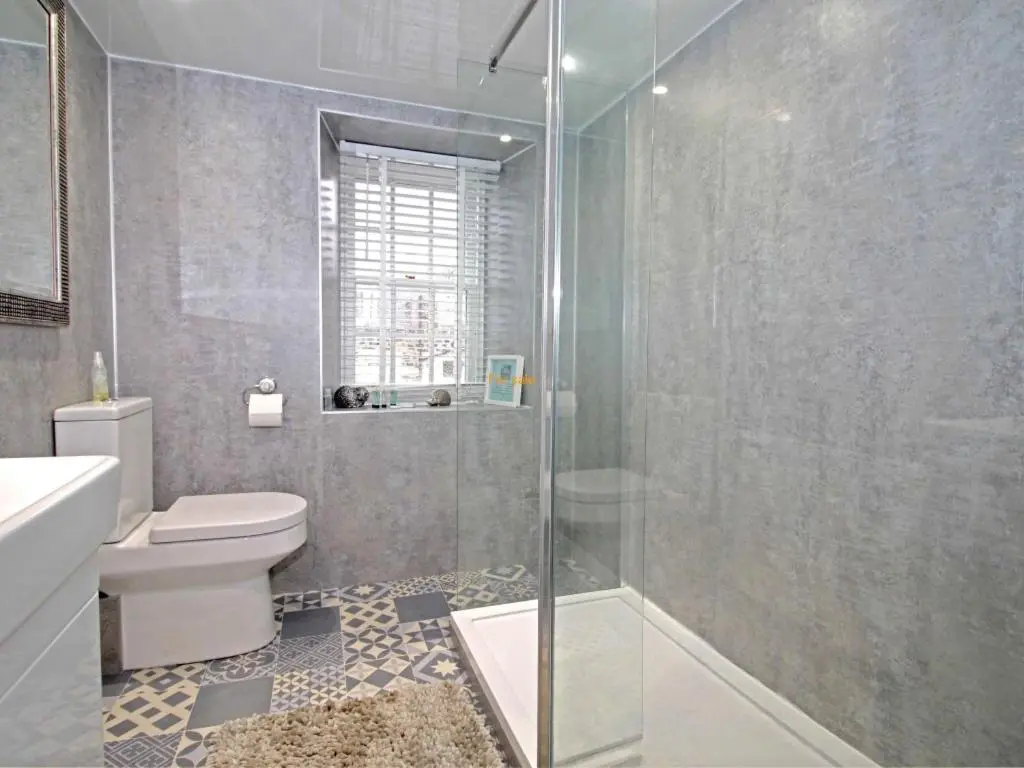 a bathroom with a toilet and a glass shower at The Garden Arms Pub and Rooms in Gardenstown