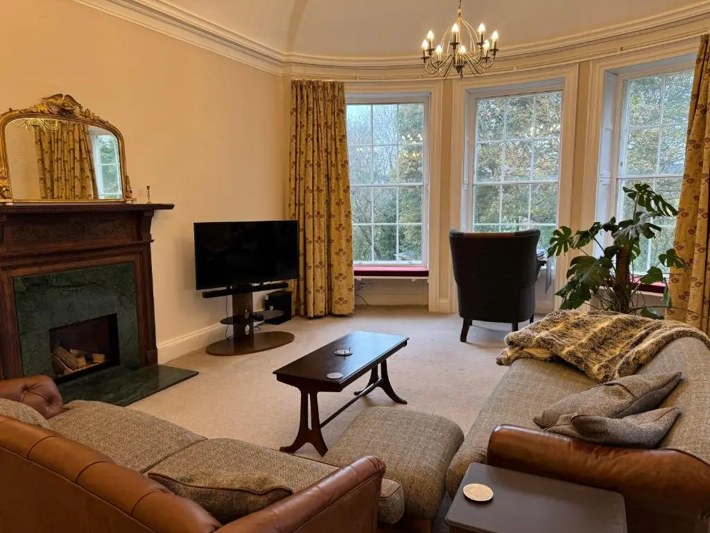 a living room with a couch and a fireplace at Aultnaskiach House Apartment, Inverness in Inverness