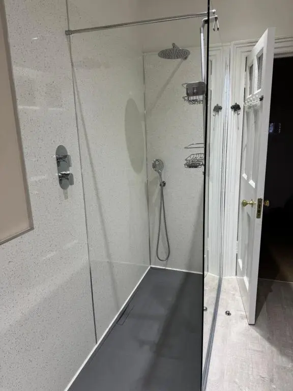 a shower with a glass door in a bathroom at Aultnaskiach House Apartment, Inverness in Inverness