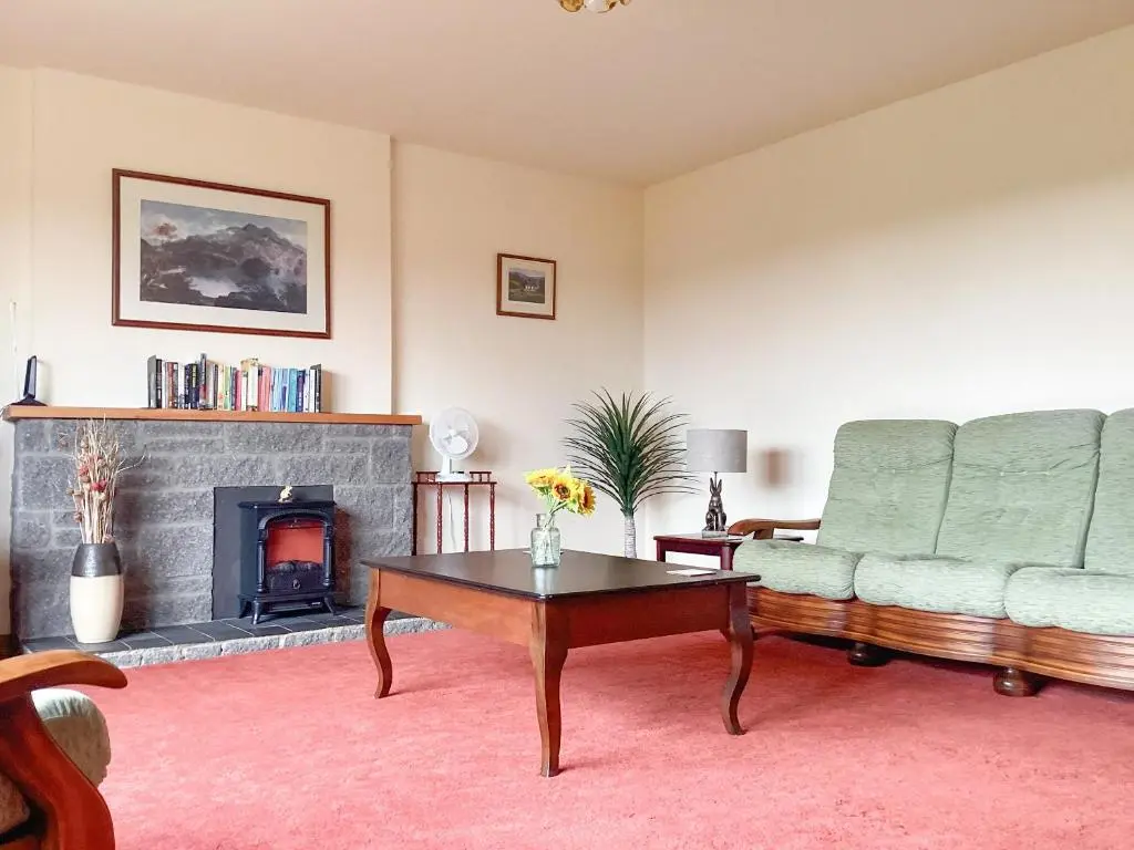 a living room with a couch and a fireplace at The Junipers in Tain