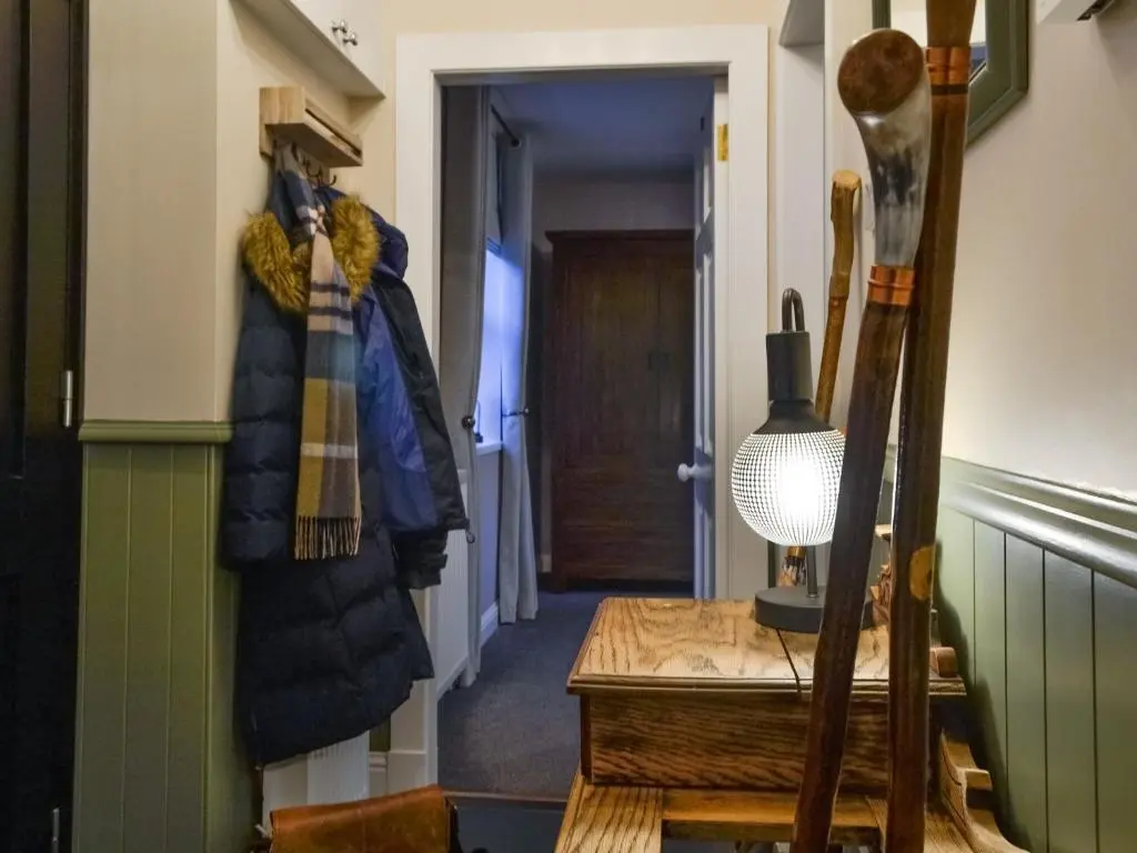 a hallway with coats hanging on a wall at Logiemar Cottage in Ballater