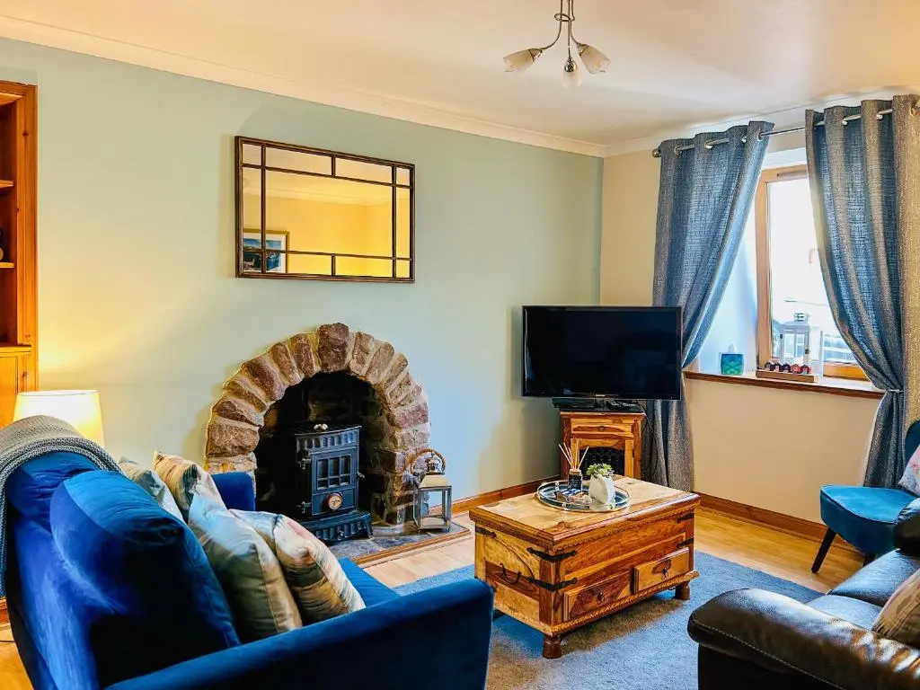 a living room with a couch and a fireplace at Seahaven Cottage in Portknockie