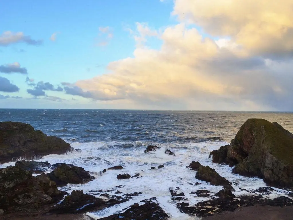 a view of the ocean with rocks in the water at Seahaven Cottage in Portknockie