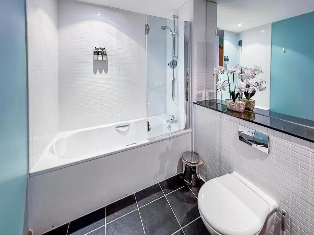 a bathroom with a toilet and a tub and a sink at No4 The Links Apartments in Brora