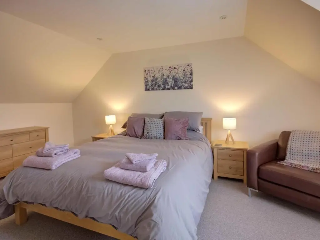 a bedroom with a bed with purple towels on it at Darna House in Tain