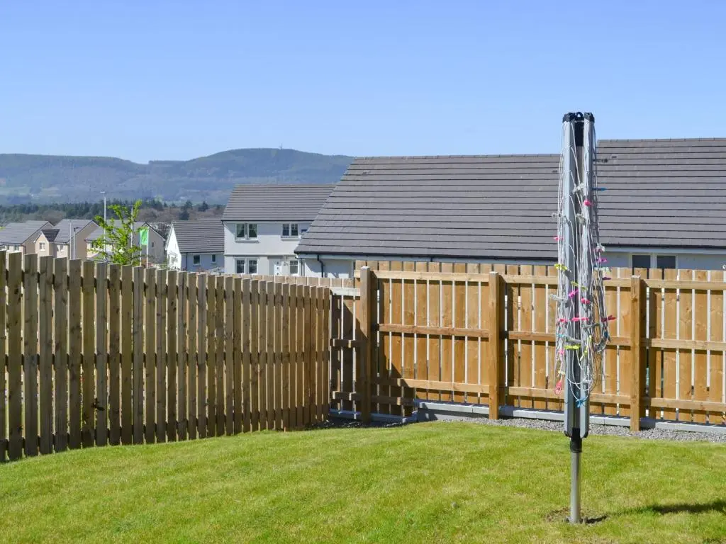 a wooden fence with an american flag on a pole at Faillie in Inverness