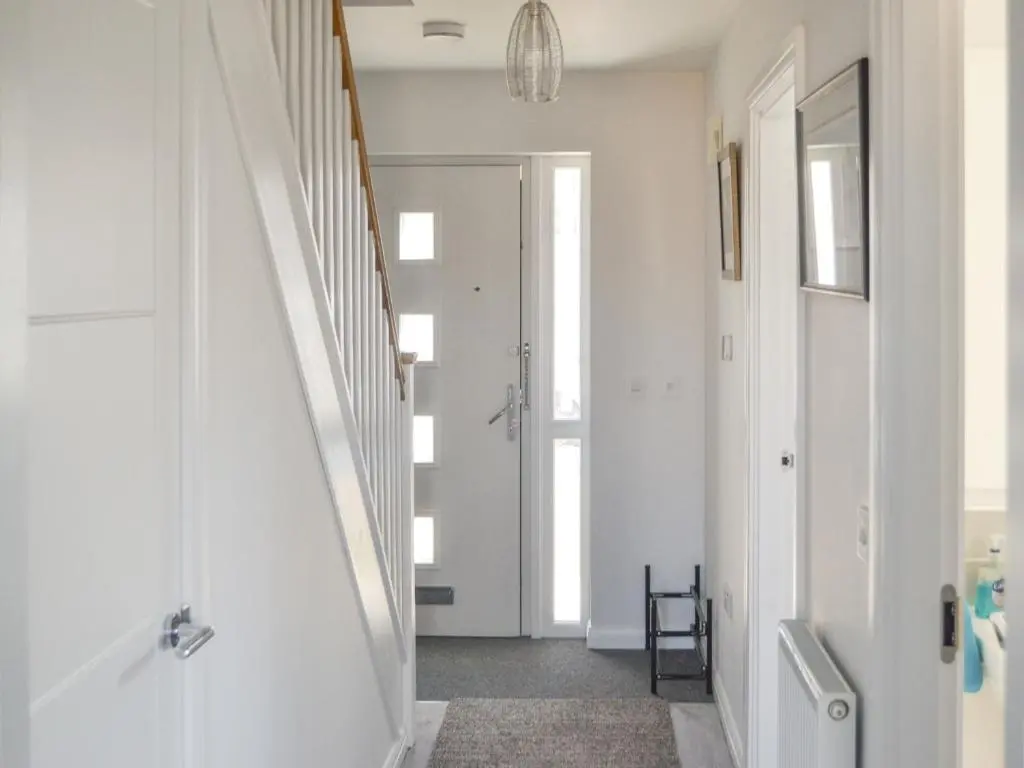 a hallway with white walls and a white staircase at Faillie in Inverness