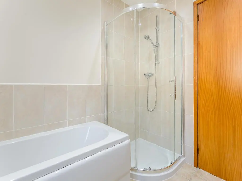 a bathroom with a shower and a white tub at Mermaid View in Balintore