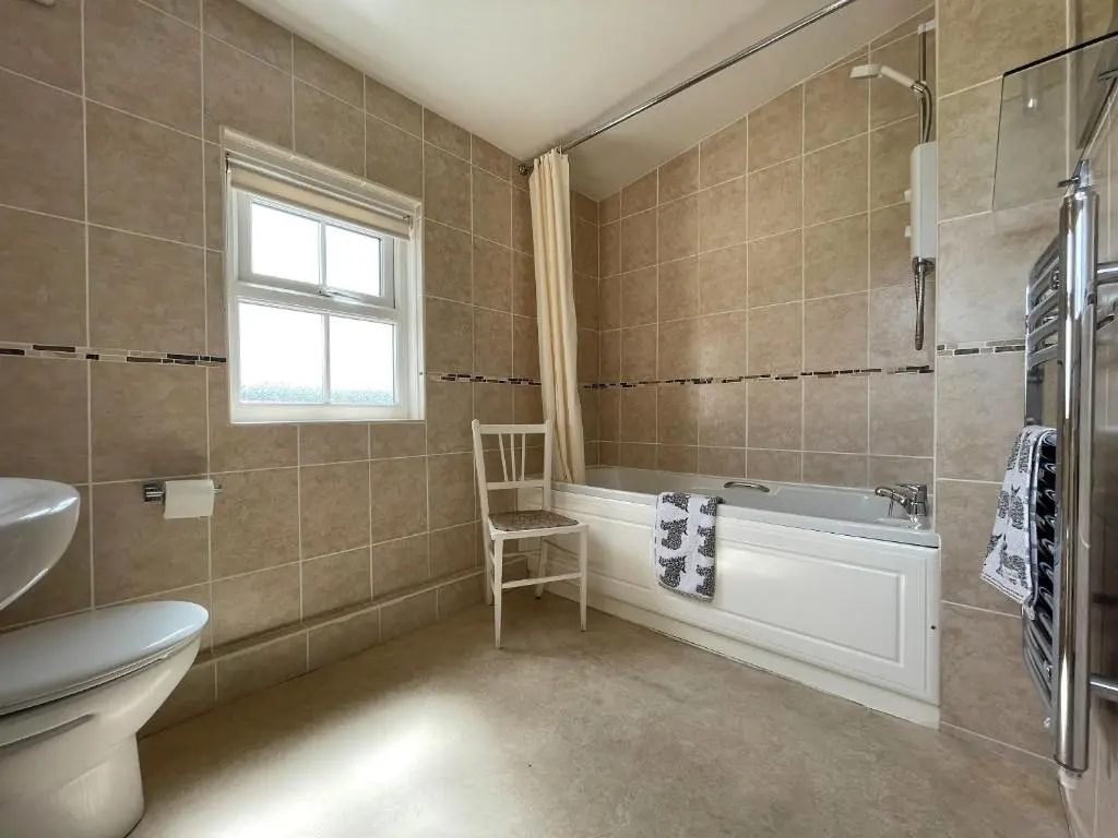 a bathroom with a tub and a toilet and a window at Pine Cottage - Dalcross in Dalcross