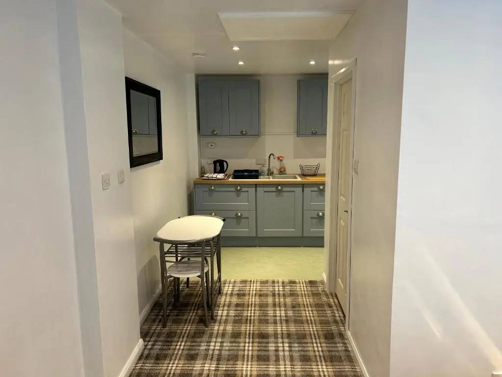 a small kitchen with a table and a table at One bed and bathroom with kitchen for self catering Alness in Alness