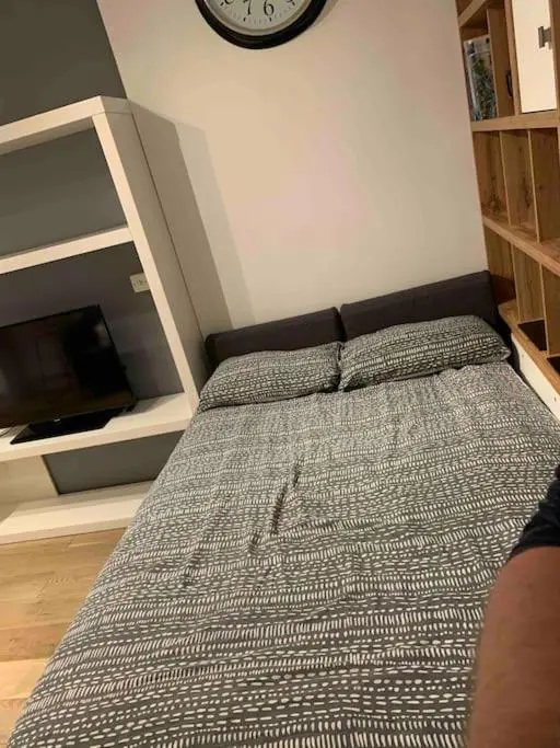 a bed in a bedroom with a clock on the wall at Luxury studio flat in a coastal town of Nairn in Nairn