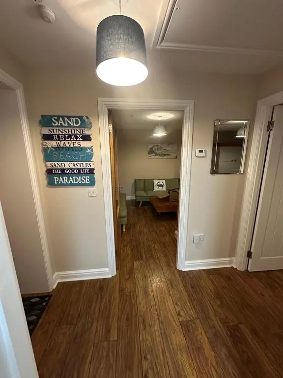 a room with a hallway with a sign on the wall at Pebble Cottage in Golspie