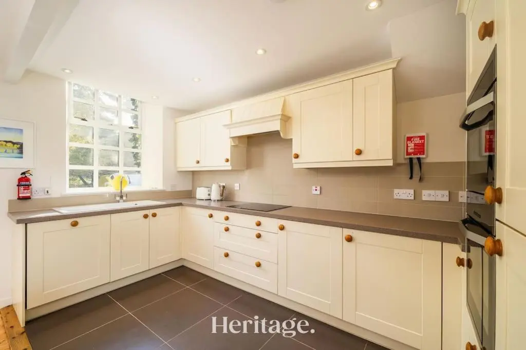 a kitchen with white cabinets and a sink at The Stables Cottage, Aboyne, Peaceful Stay in Royal Deeside in Aboyne
