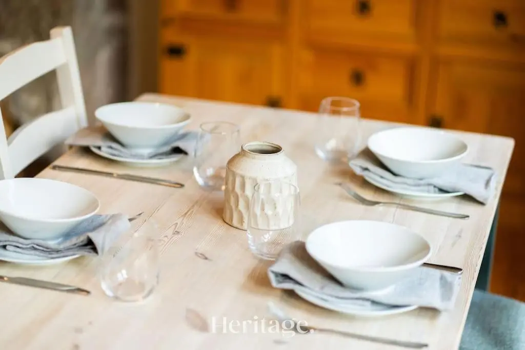 a table with plates and bowls and glasses on it at The Stables Cottage, Aboyne, Peaceful Stay in Royal Deeside in Aboyne