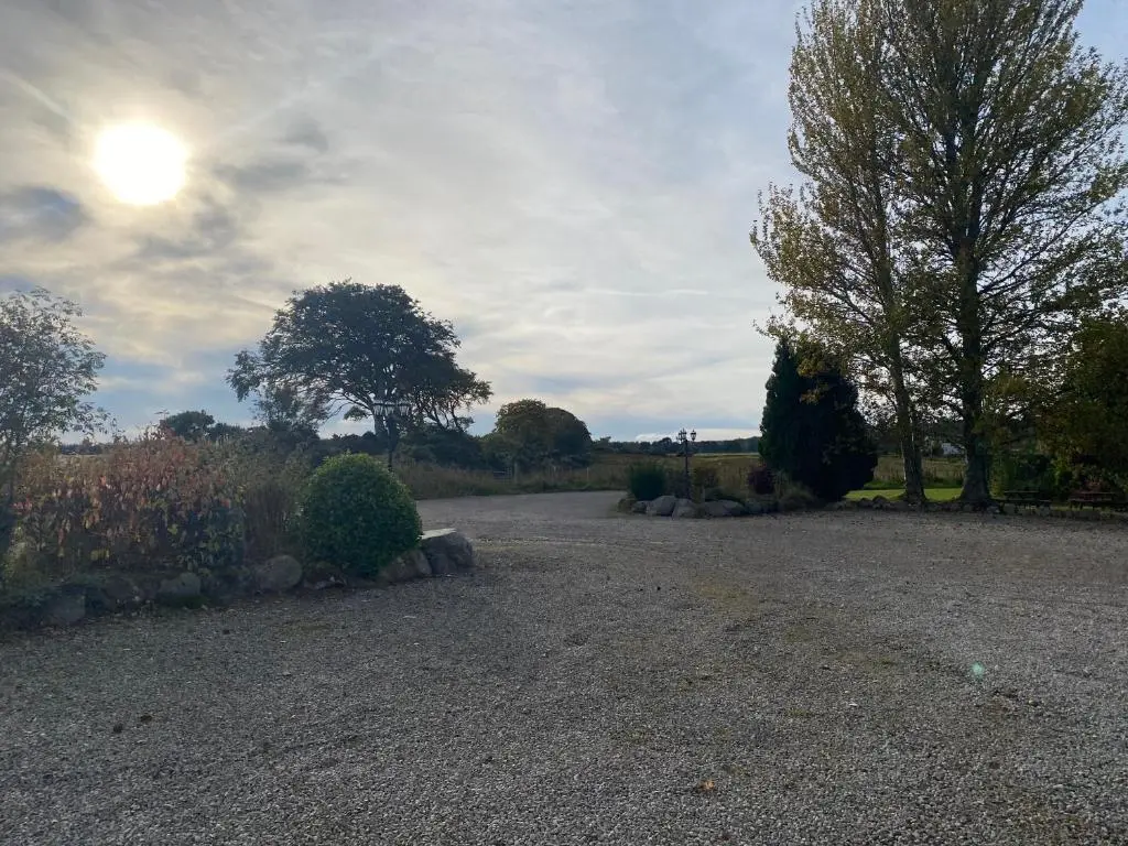 a gravel road with trees and bushes in a field at Carnegie Lodgings, Tain in Tain