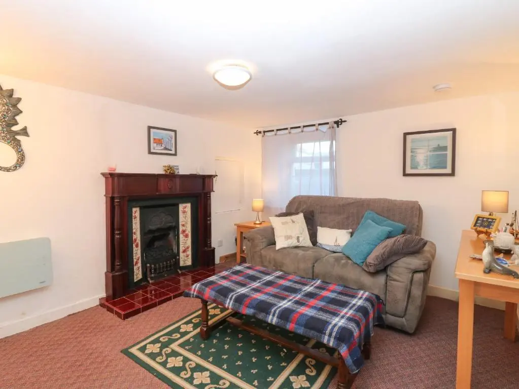 a living room with a couch and a fireplace at 171 Seatown in Buckie