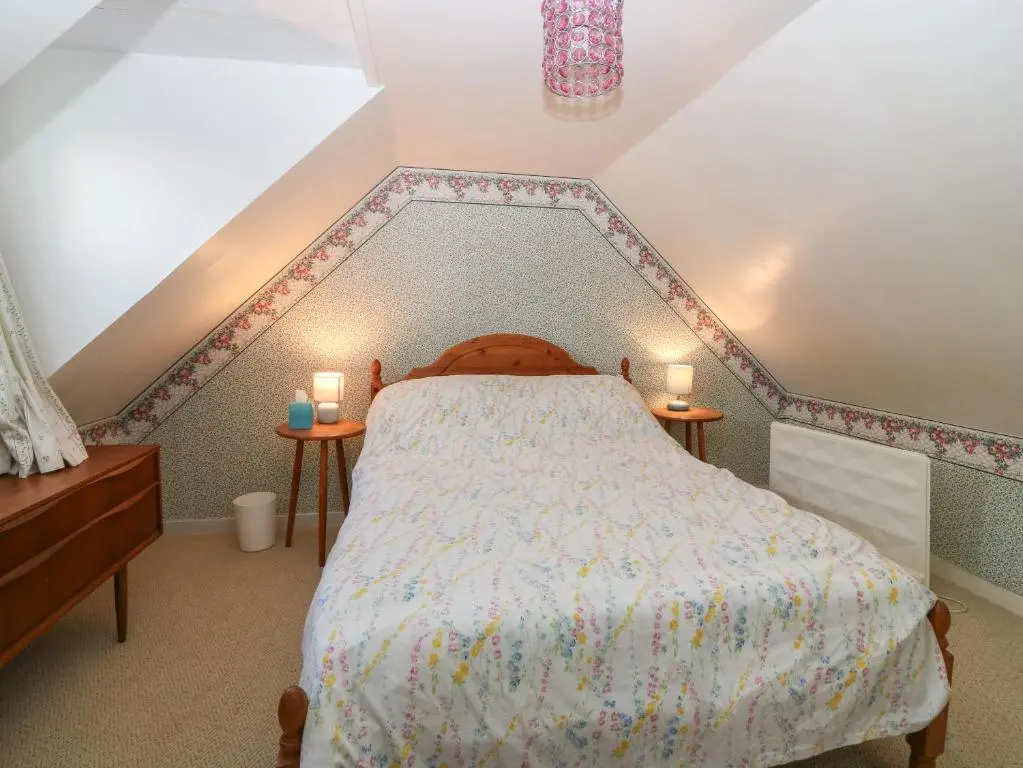 a bedroom with a bed with two candles on two tables at 171 Seatown in Buckie