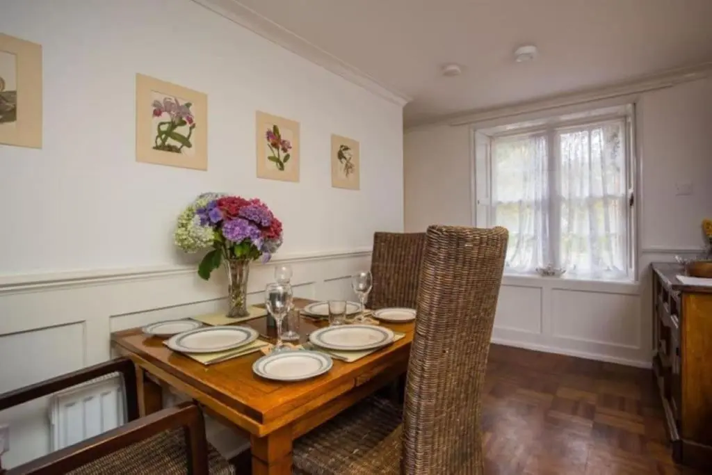 a dining room with a wooden table and chairs at The Garden Flat - Ardullie Lodge in Dingwall