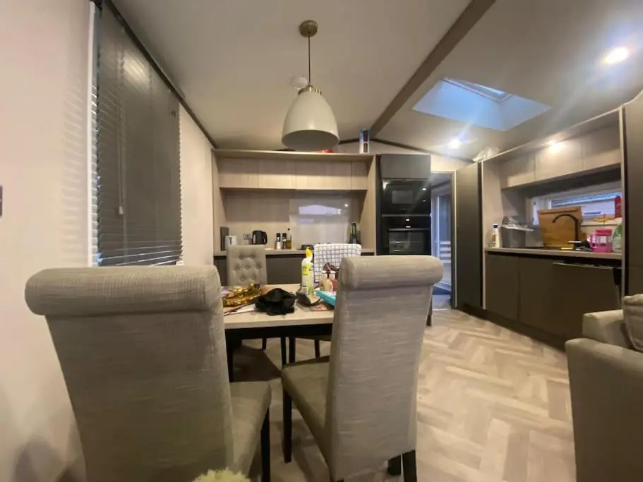 a kitchen and dining room with a table and chairs at Corrie Fee Lodge in Boat of Garten