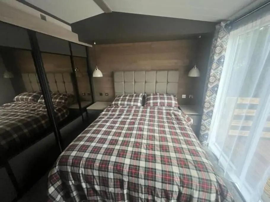a bedroom with two twin beds and a window at Corrie Fee Lodge in Boat of Garten