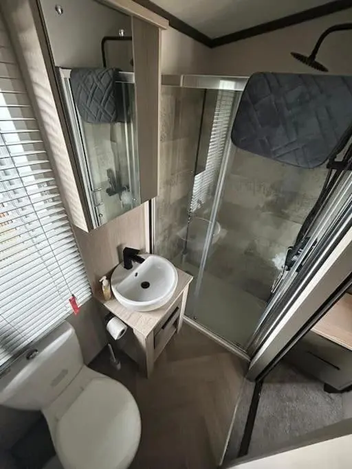 a bathroom with a toilet and a sink and a shower at Corrie Fee Lodge in Boat of Garten