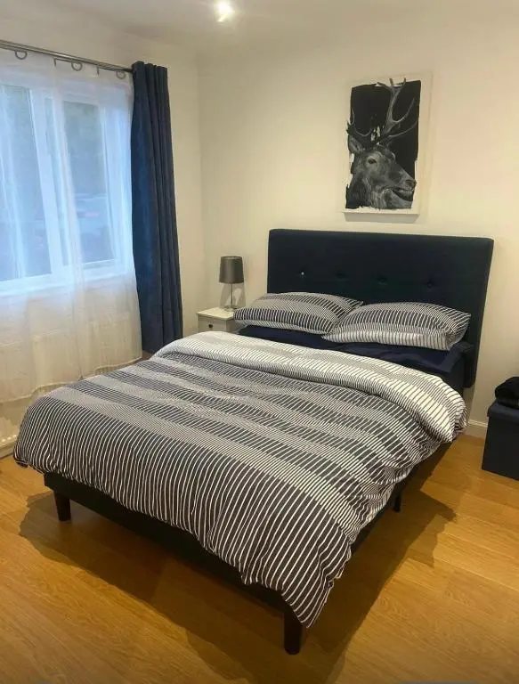 a bed with a black and white striped comforter in a bedroom at Balmanach Court in Beauly