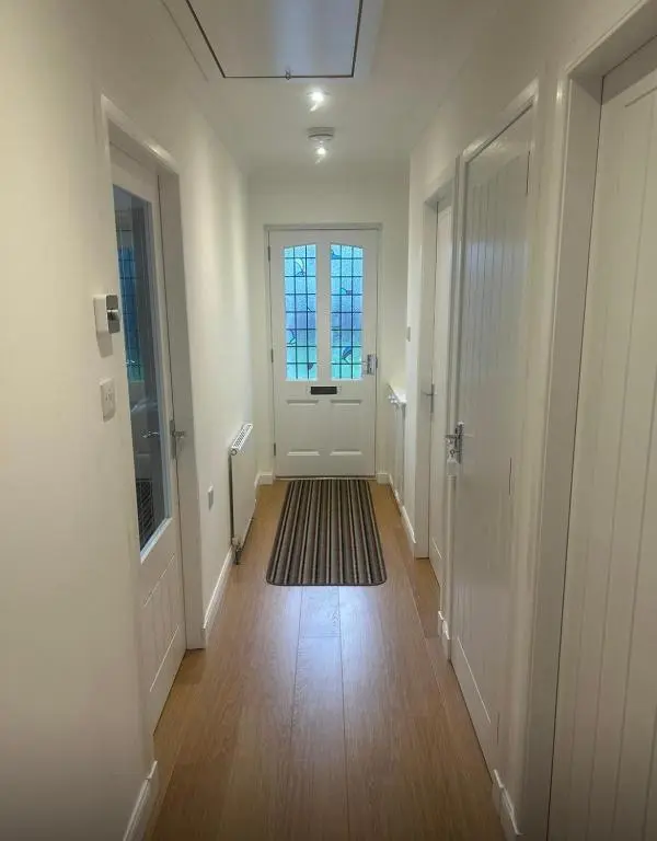 an empty hallway with a door and a rug at Balmanach Court in Beauly