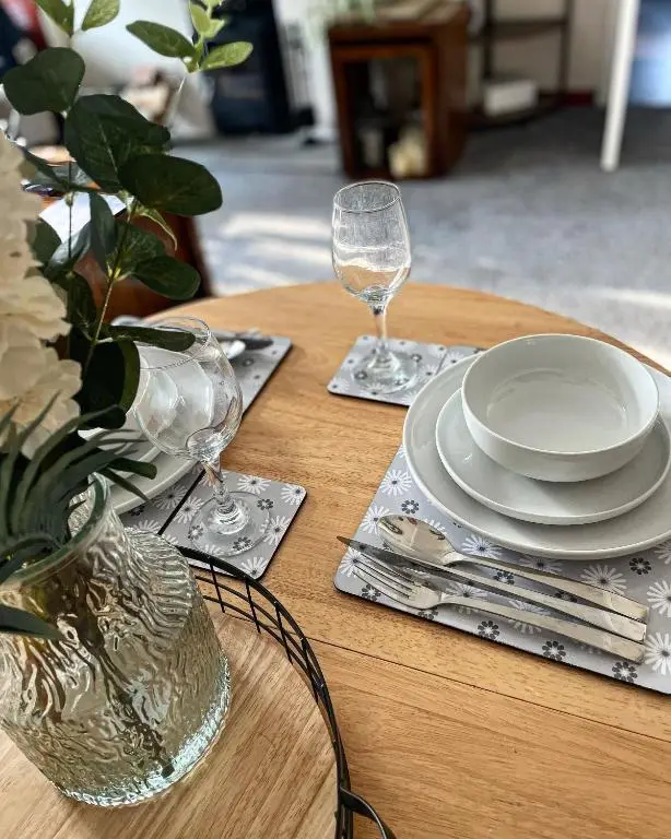 a wooden table with plates and wine glasses on it at Ramsay Lane in Lossiemouth